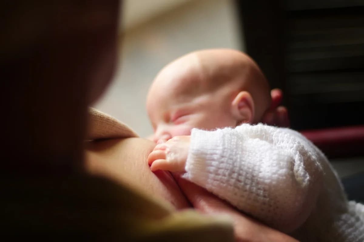 Close-up of a mother breastfeeding her newborn baby.