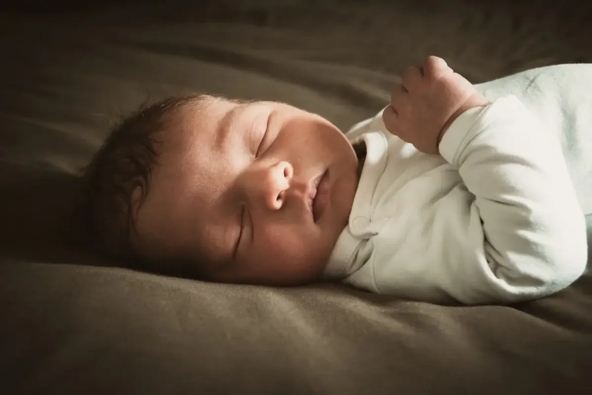 Close-up of a sleeping newborn baby in soft light.