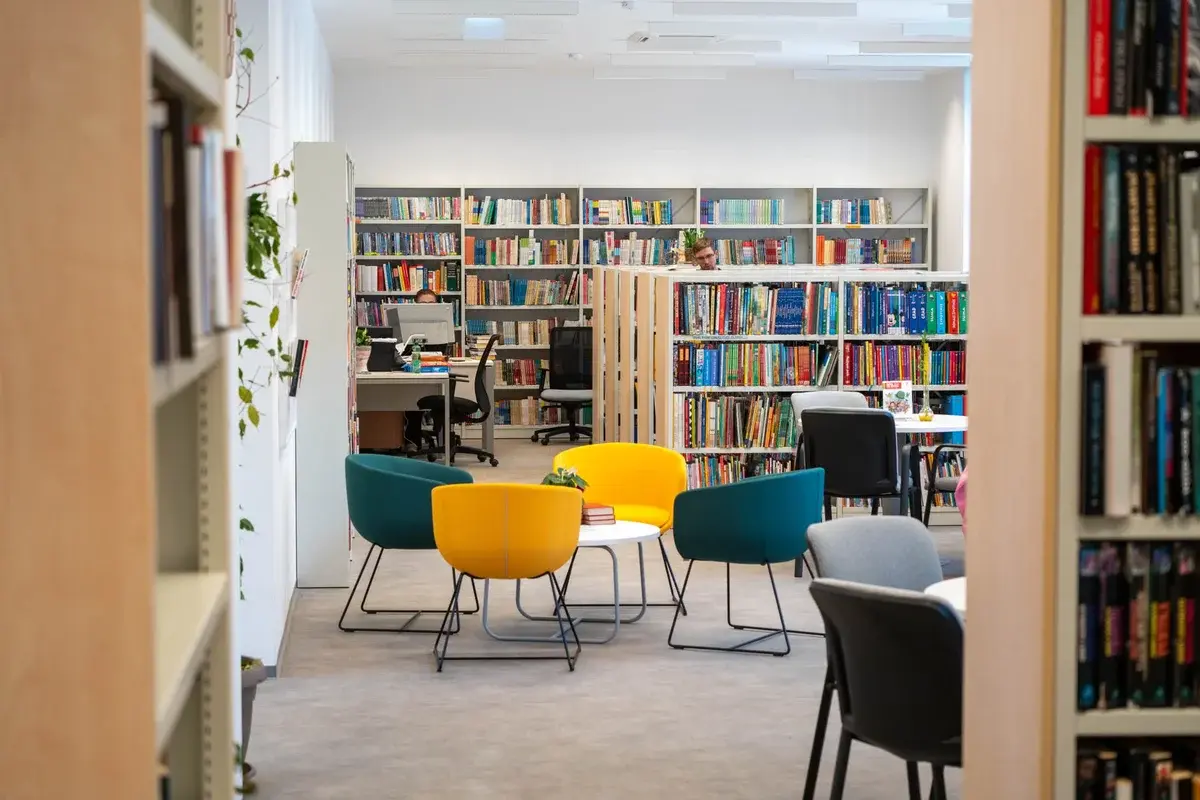 A bright library with colorful chairs and bookshelves.
