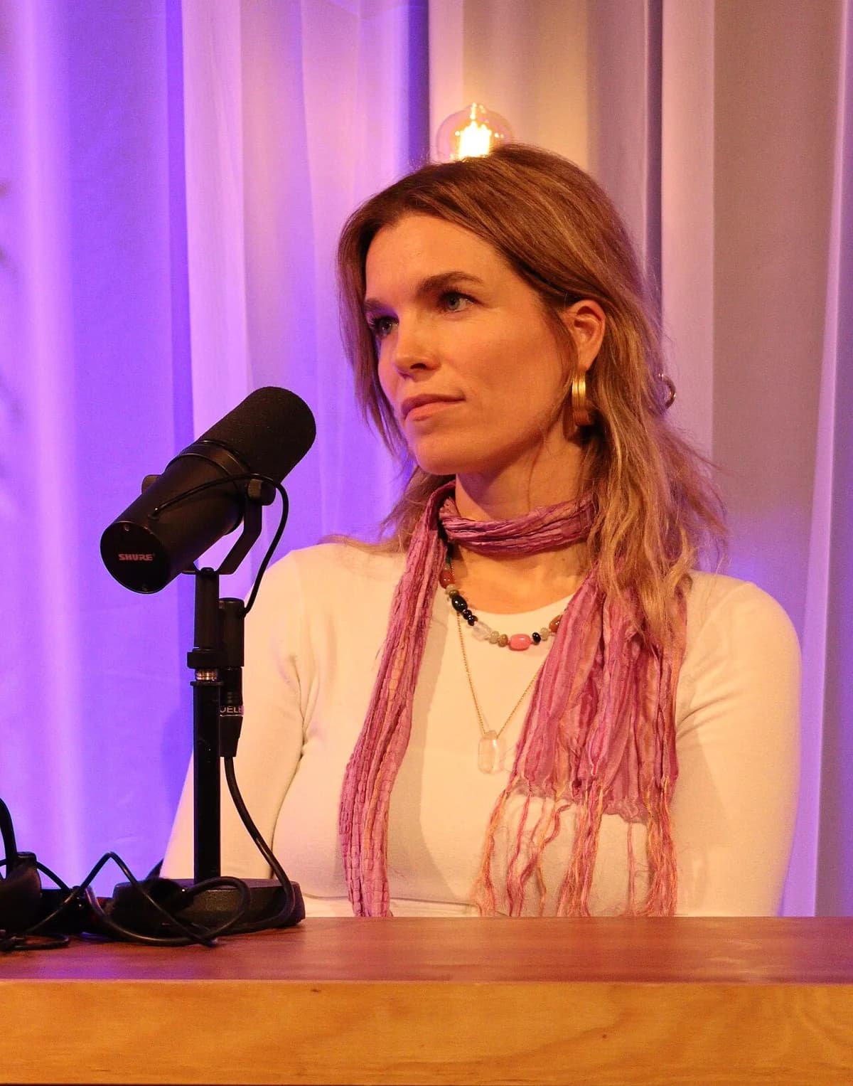 Marie Bach Hansen speaking into a microphone during a podcast recording.
